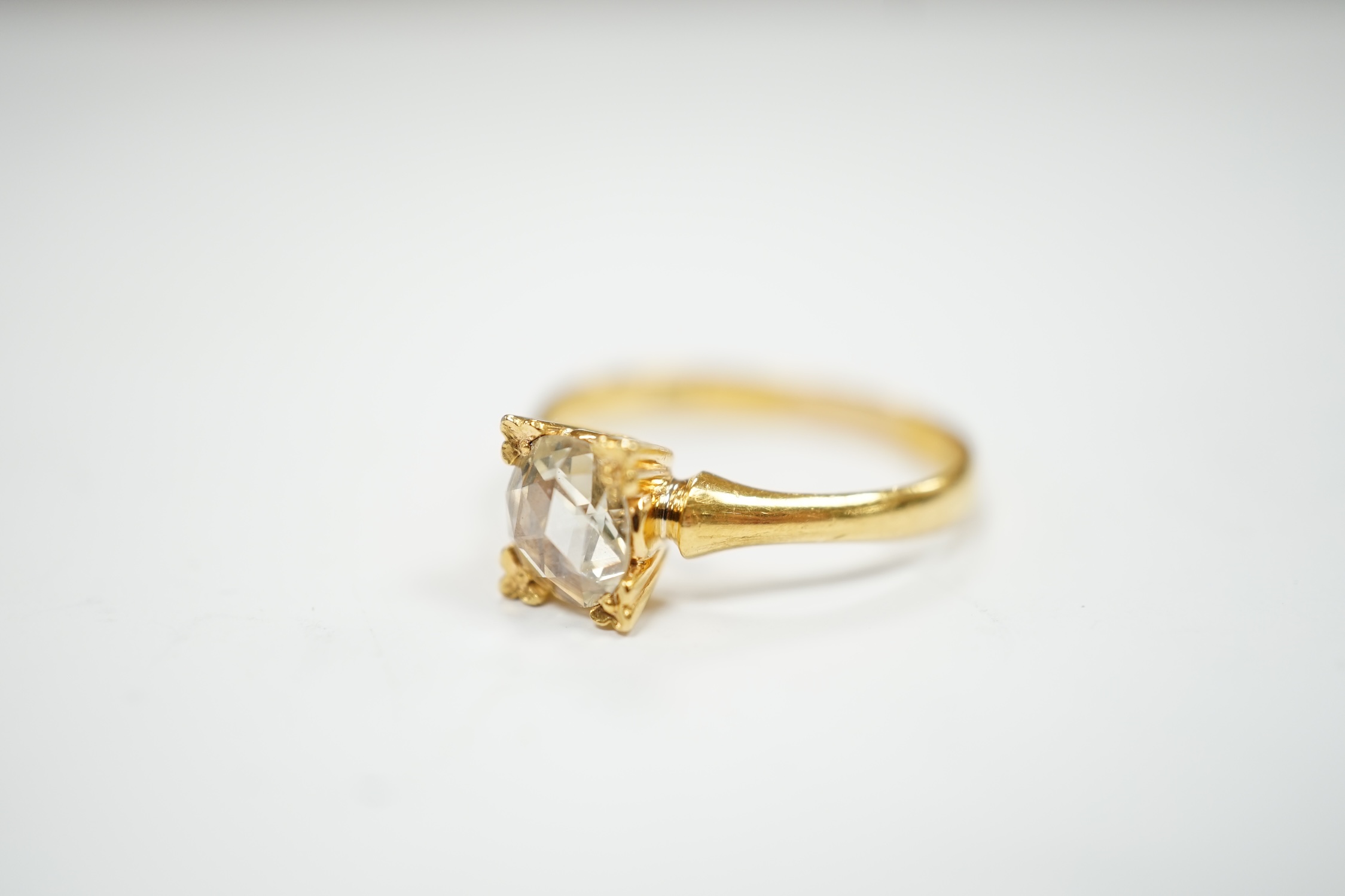 A yellow metal (stamped 22) and solitaire oval facet cut diamond set ring, size M, gross weight 2.9 grams.